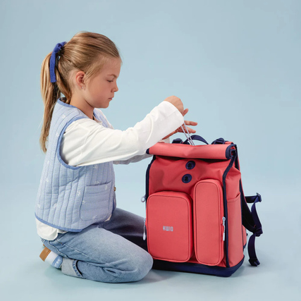 Rosa Schulrucksack mit blauen Akzenten, genutzt von einem Kind, das ihn öffnet.