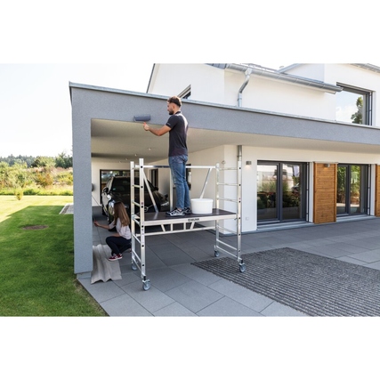 Klappbares Leitergerüst, aufgestellt mit Person beim Streichen unter einem Vordach.