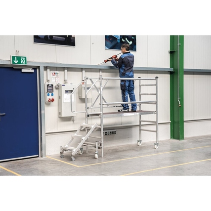 Rollgerüst aus Aluminium mit einer Person, die an einer Wand arbeitet.