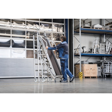 Rollgerüst aus Aluminium, zusammengeklappt und in einem Lagerumfeld transportiert.