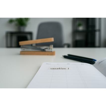 Transparenter tesafilm® PAPER auf einem Notizbuch mit dem eingegebenen Wort "vacation".