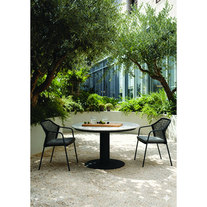 Gartenstuhl Burano in anthrazit mit Tisch und Dekoration in einem begrünten Außenbereich.