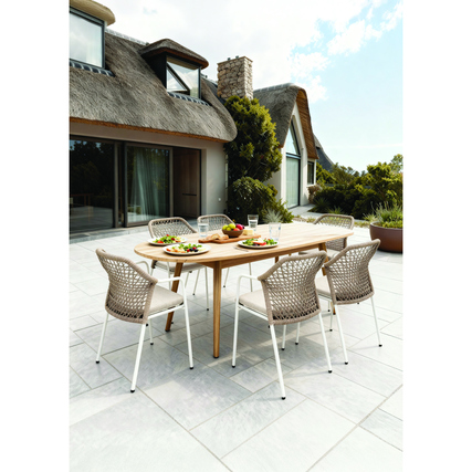 Gartenstuhl Burano in sandfarbig mit Tisch und Essen im Freien, stilvolle Terrasse als Hintergrund.