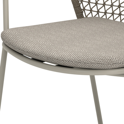 Gartenstuhl mit sandfarbenem Sitzkissen und eleganter, geflochtener Rückenlehne.