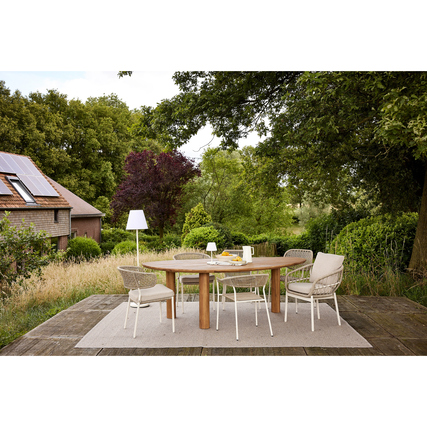 Gartenstuhl mit gewebter Sitzfläche und Rückenlehne in einem Außenbereich unter Bäumen.