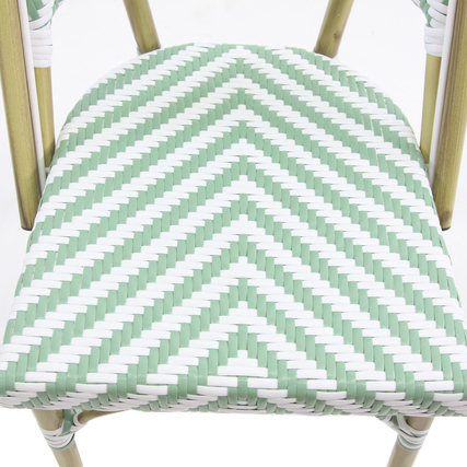 Stuhl mit grün-weißem, chevronförmigem Polyrattan-Sitz und goldfarbenem Gestell.