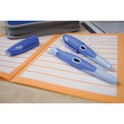 Füller und Schreibgeräte in Blau- und Hellblau-Tönen auf einem beschriebene Blatt Papier.