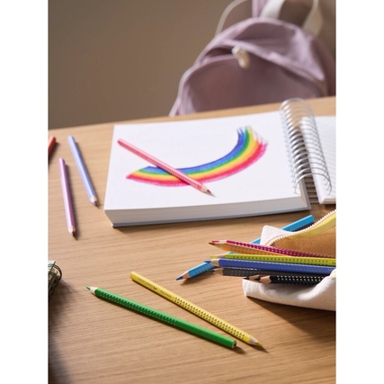 Faber-Castell Buntstifte in einer Szene mit gezeichnetem Regenbogen, Notizbuch und Rucksack.