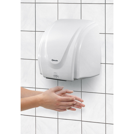 Bartscher Handtrockner an einer Fliesenwand mit einer Hand, die darunter gehalten wird.