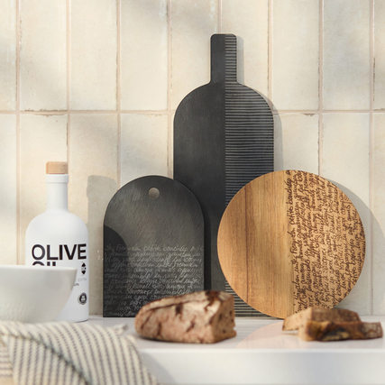 Schneidebrett aus Akazienholz mit gelaserter Typografie, dekorativ gegen geflieste Wand.