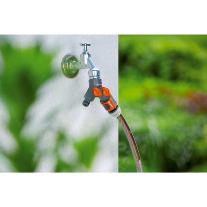 GARDENA 2-Wege-Ventil am Wasserhahn mit zwei Schlauchanschlüssen im Garten.