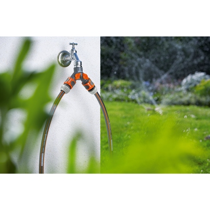 2-Wege-Verteiler mit zwei Schlauchanschlüssen ist an einem Wasserhahn montiert.