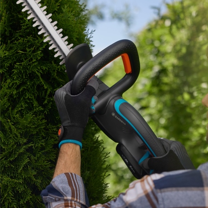 GARDENA Heckenschere EasyCut 55/18V in Aktion beim Schneiden einer Hecke.