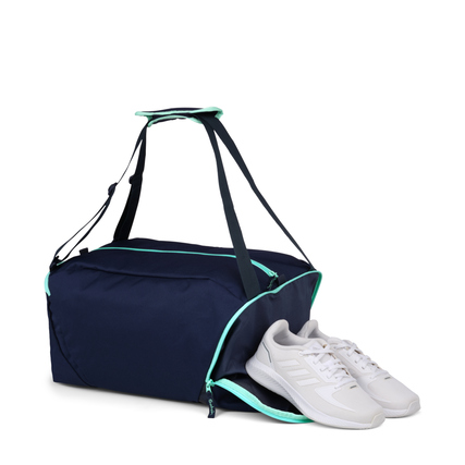 Sporttasche in Ocean Mint mit verstellbarem Schultergurt, neben einem Paar weißer Schuhe.