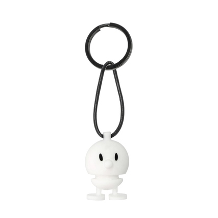 Schlüsselanhänger in Form eines kleinen weißem Hoptimist mit schwarzen Augen und einem Ring.