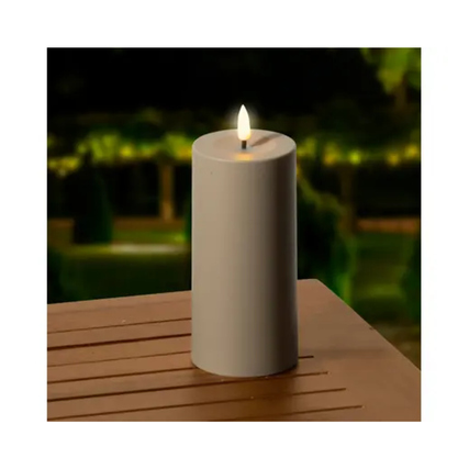 Dekorative braune Solarleuchte im Kerzendesign auf einem Tisch im Freien mit sanftem Lichtschein.