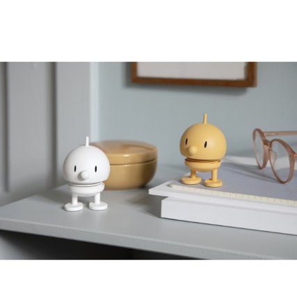 Dekorationsfigur HOPTIMIST Soft Bumble S in Weiß neben einer weiteren Figur auf einem Tisch.
