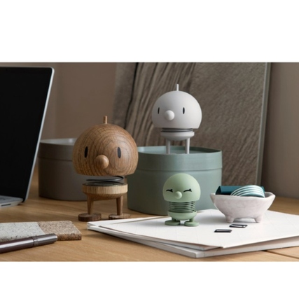 HOPTIMIST Dekorationsfigur Soft Bimble S in Olivgrün auf einem Schreibtisch mit weiteren Figuren.