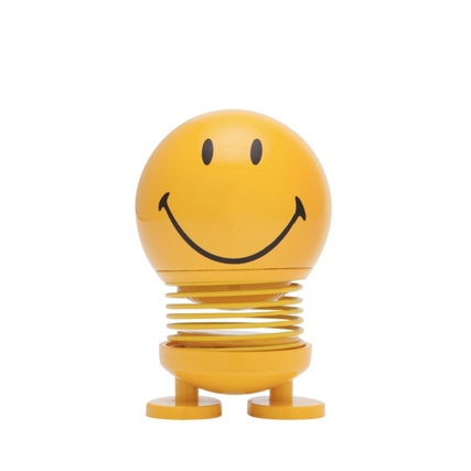 Gelbe Dekorationsfigur in Smiley-Form mit lächelndem Gesicht und spiralförmigem Unterteil.