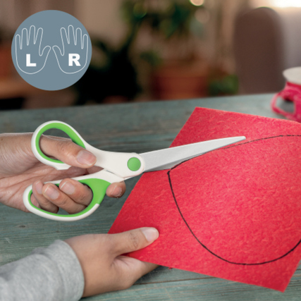 Grüne Universalschere wird verwendet, um rotes Papier entlang einer Linie zu schneiden.