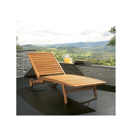 Holzliege mit verstellbarem Rückenteil auf einer Terrasse mit Ausblick ins Grüne.