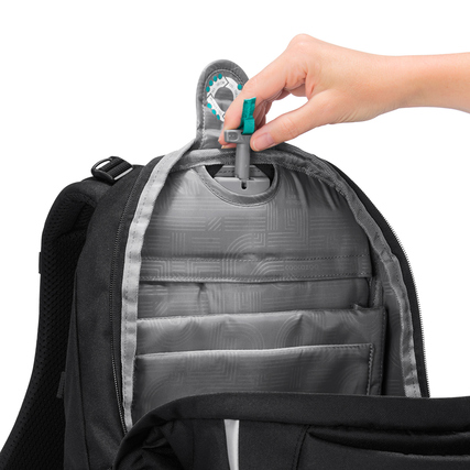 Rucksacköffnung mit Organizer-Taschen und Hand, die einen Stift hält.