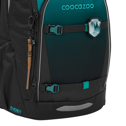 Schulrucksack in Teal-Schattierungen mit Dekoration und Gurtbändern an der Seite.