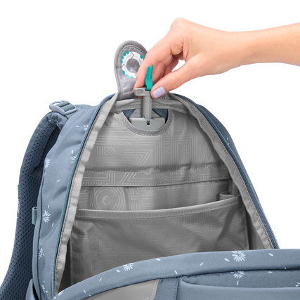 Öffnung des COOCAZOO Schulrucksacks MATE mit Innenaufteilung und Hand, die einen Clip hält.