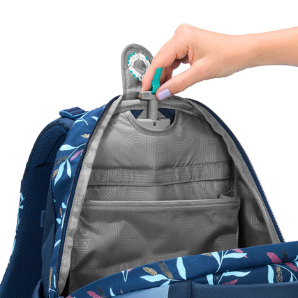 Innensicht eines Schulrucksacks mit verstellbarem Fach und Hand, die einen Clip hält.