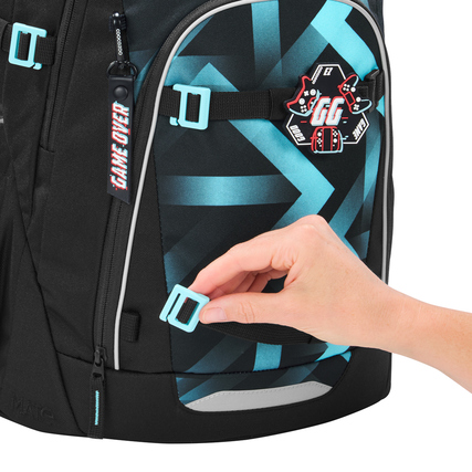 Schulrucksack COOCAZOO MATE mit Hand, die einen abnehmbaren Clip an der Vorderseite zeigt.