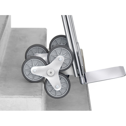 Treppensackkarre aus Aluminium mit Sicherheitsgriffen und dreiarmigen Rad-Sternen an Treppe.
