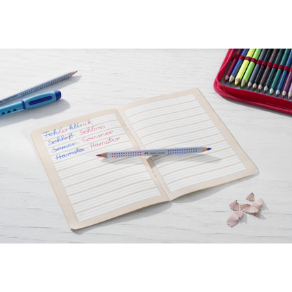 Bicolor Silbentrennstift auf einem beschriebenen Arbeitsheft, umgeben von Schulutensilien.