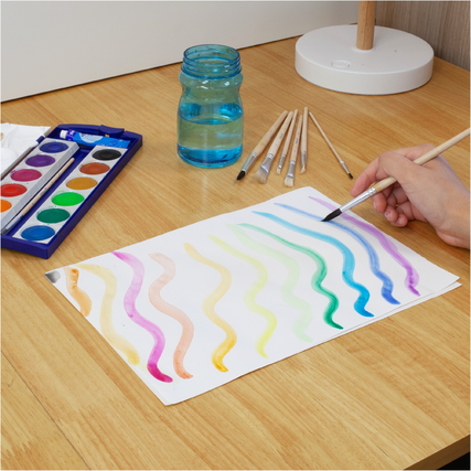 Pinselset von Pelikan mit verschiedenen Pinselgrößen und Wasserfarben auf einem Tisch.