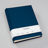Blaues Fotoalbum aus Buchleinen mit breitem weißen Etikett auf dem Cover.