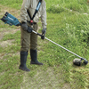 Akku-Freischneider in Gebrauch, gehalten von einer Person im Freien mit Gras im Hintergrund.